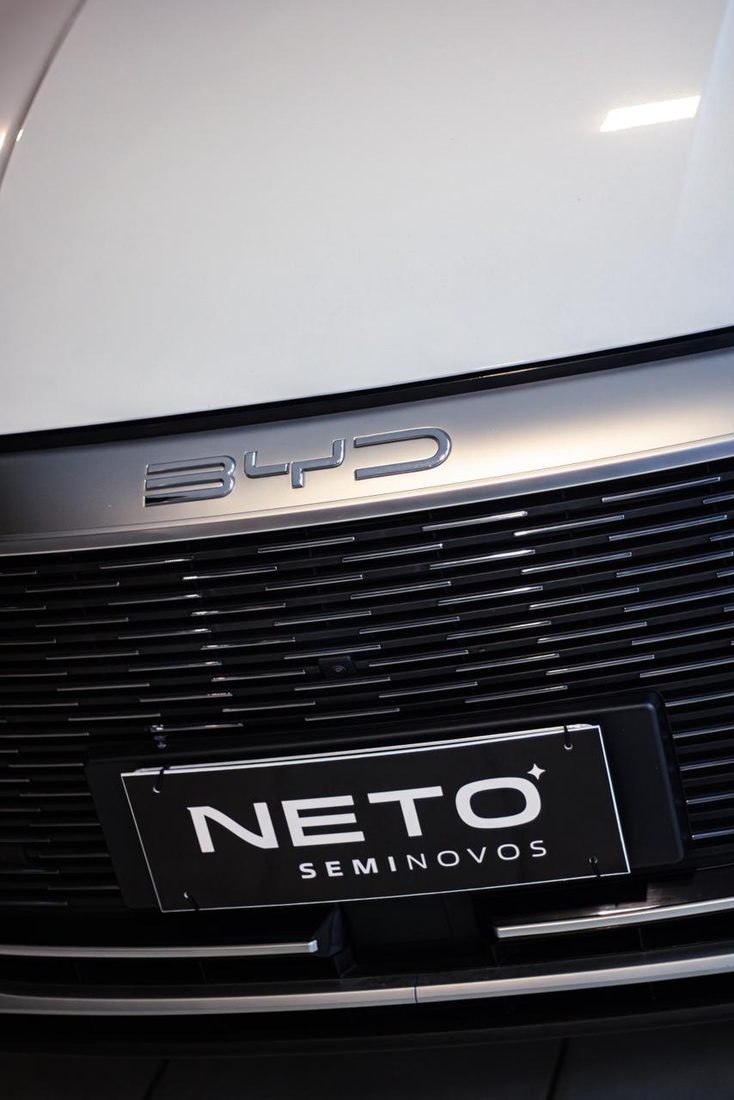 Frente de um BYD no salão da Neto Seminovos, com a placa da loja